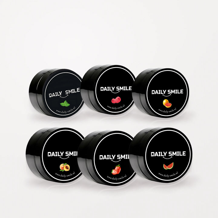 Daily Smile Ultimate Flavor Bundle, 6 potjes actieve kool tandpoeder in alle smaken op een lichte studioachtergrond