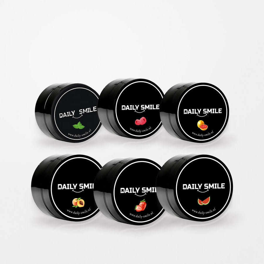 Daily Smile Ultimate Flavor Bundle, 6 potjes actieve kool tandpoeder in alle smaken op een lichte studioachtergrond