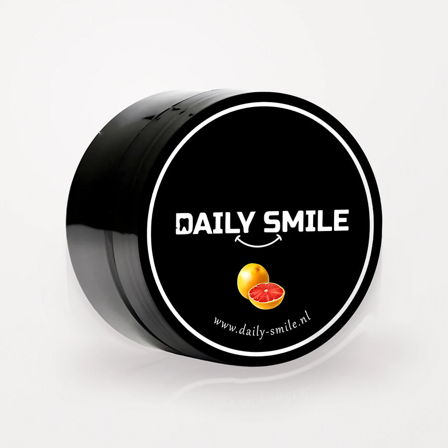 Daily Smile actieve kool tandpoeder Grapefruit, zwart potje op een lichte studioachtergrond