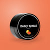 Daily Smile actieve kool tandpoeder Grapefruit op een oranje achtergrond