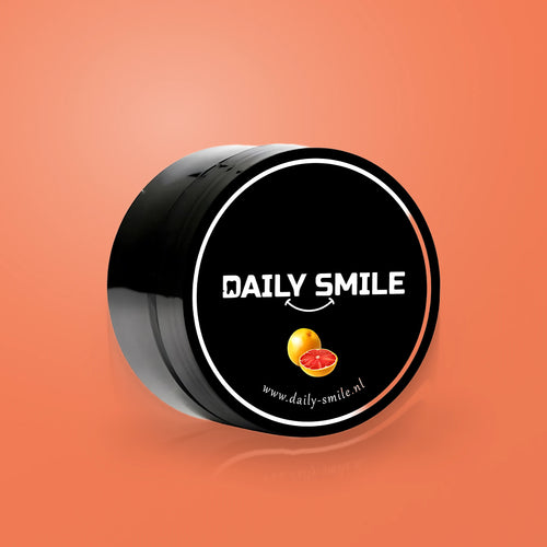 Daily Smile actieve kool tandpoeder Grapefruit op een oranje achtergrond